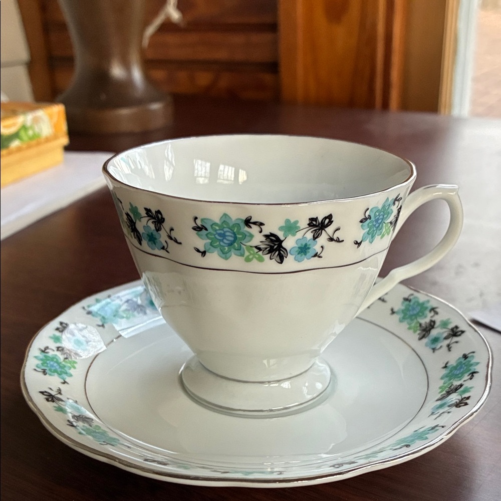Teacup and saucer with blue flowers.